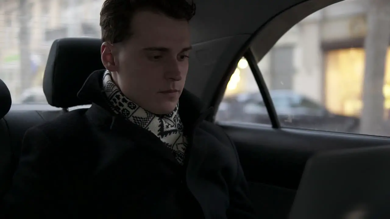 Attractive Young Male Is Riding In A Car With Laptop Opened On His Laps