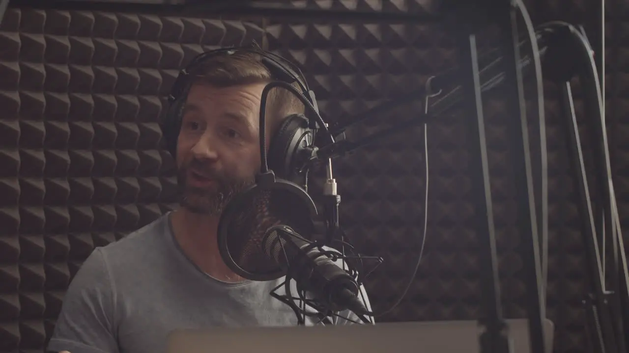 Happy Radio Broadcaster With A Beard Speaks To The Microphone In A Radio Studio