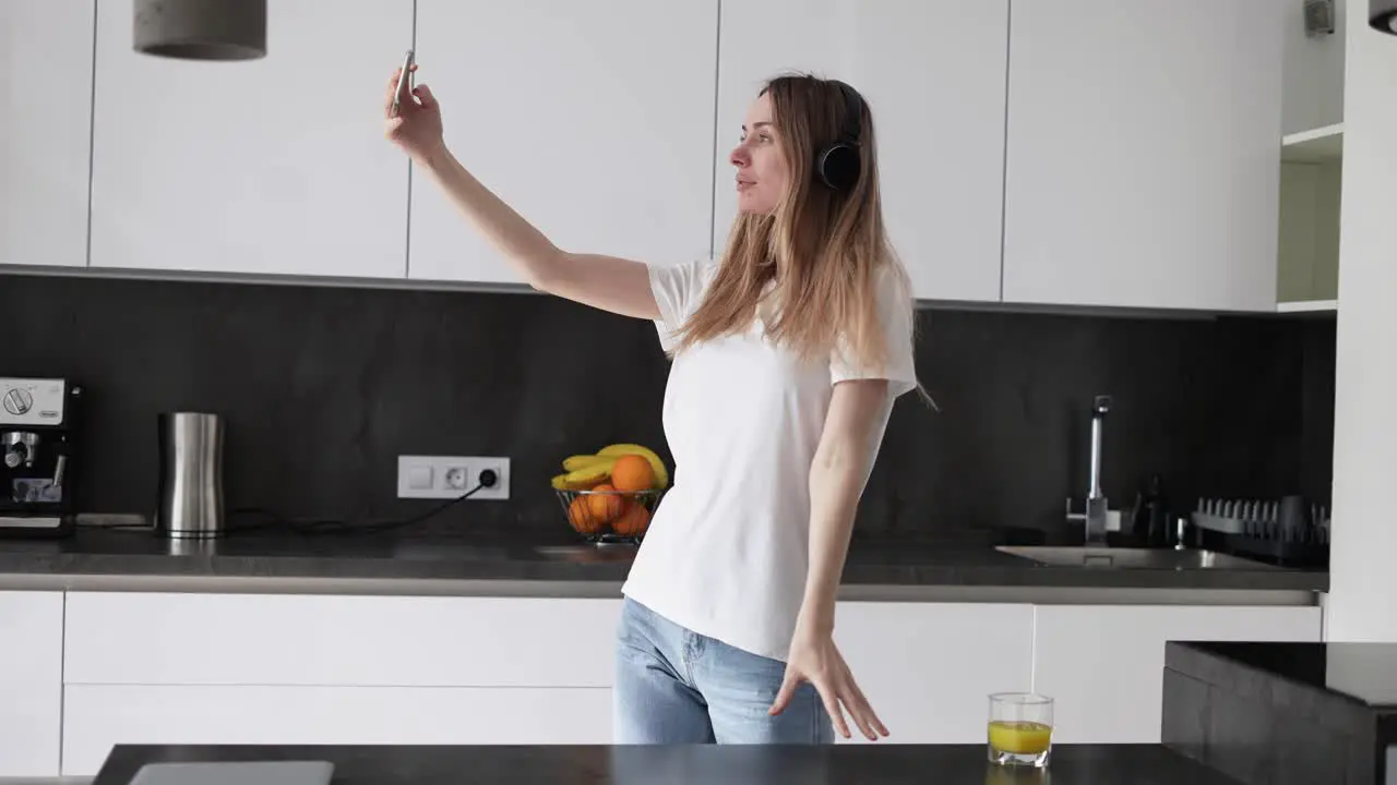 Woman In Headphones Making Selfie In The Kitchen