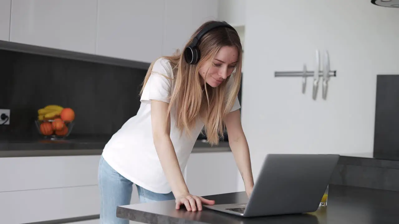 Woman Spending Time With Laptop Wearing Headphones At Home