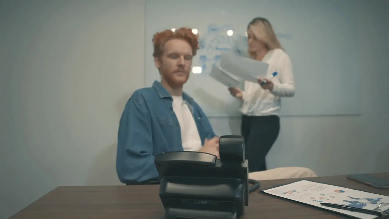 Red Haired Male And Female Having A Business Call In The Office