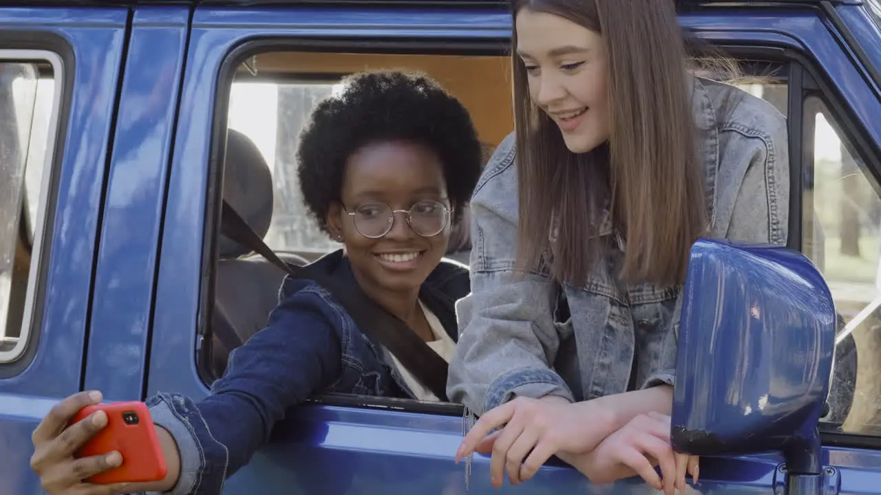 Two Beautiful Girls Take A Selfie Leaning Out Of The Window Of A Caravan During A Roadtrip