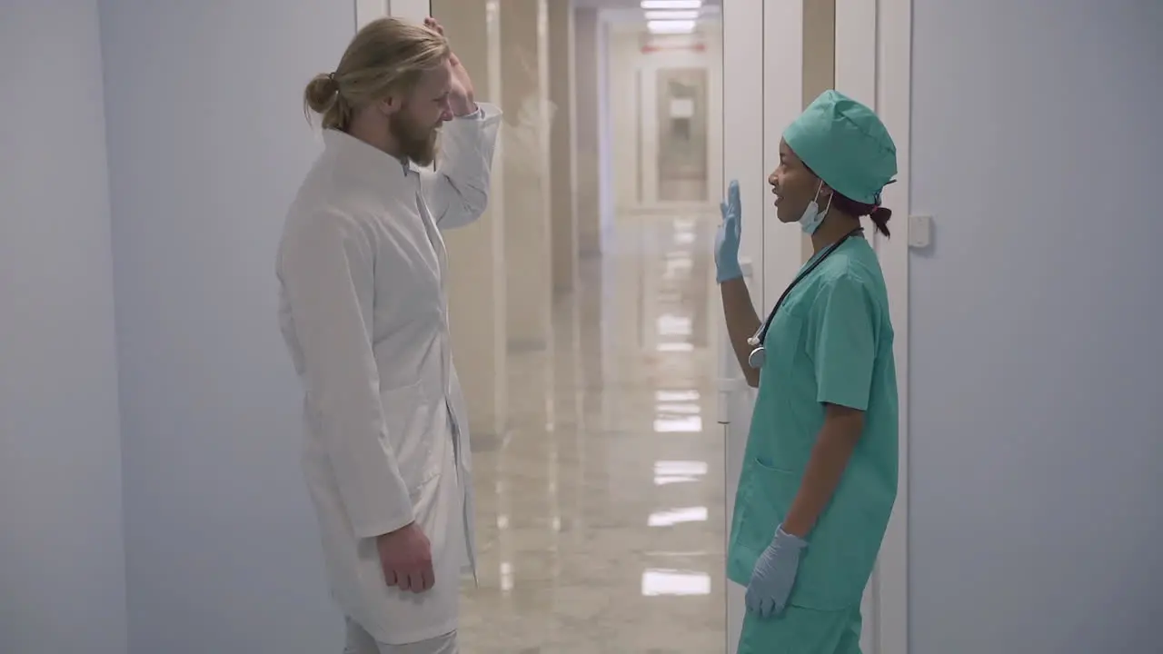 A Cute Young American Female Sanitary Professional And A Young Doctor With Long Blond Hair High Five Their Hands