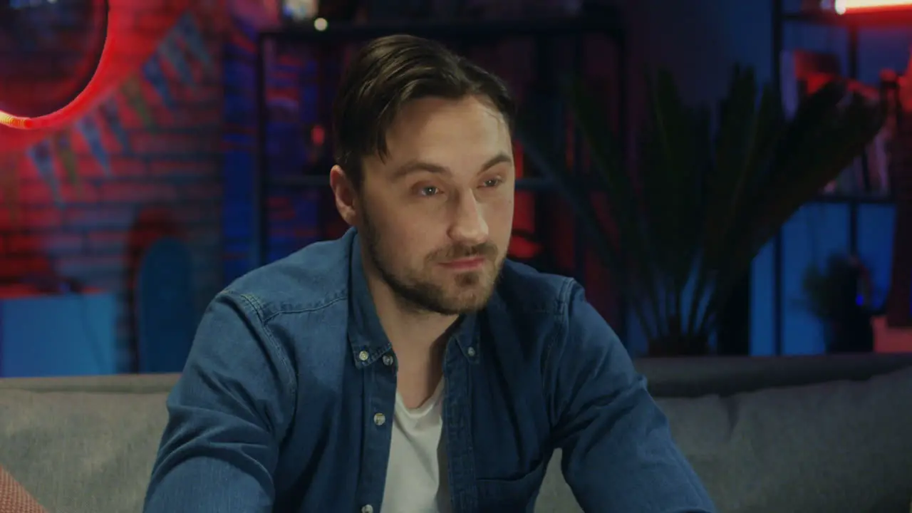 Close Up Of The Young Attractive Guy Watching Tv Attentively In The Dark Room At Night