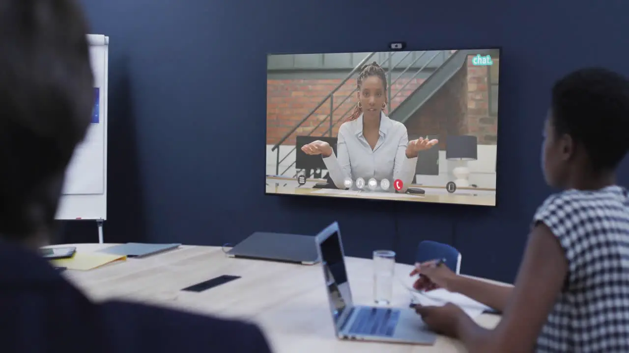 Diverse business people on video call with african american female colleague on tv screen