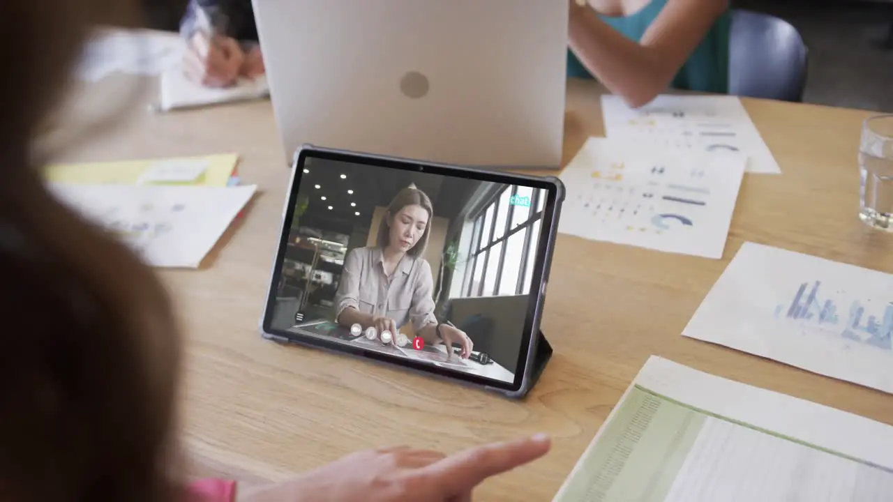 Caucasian businesswoman on tablet video call with caucasian female colleague on screen