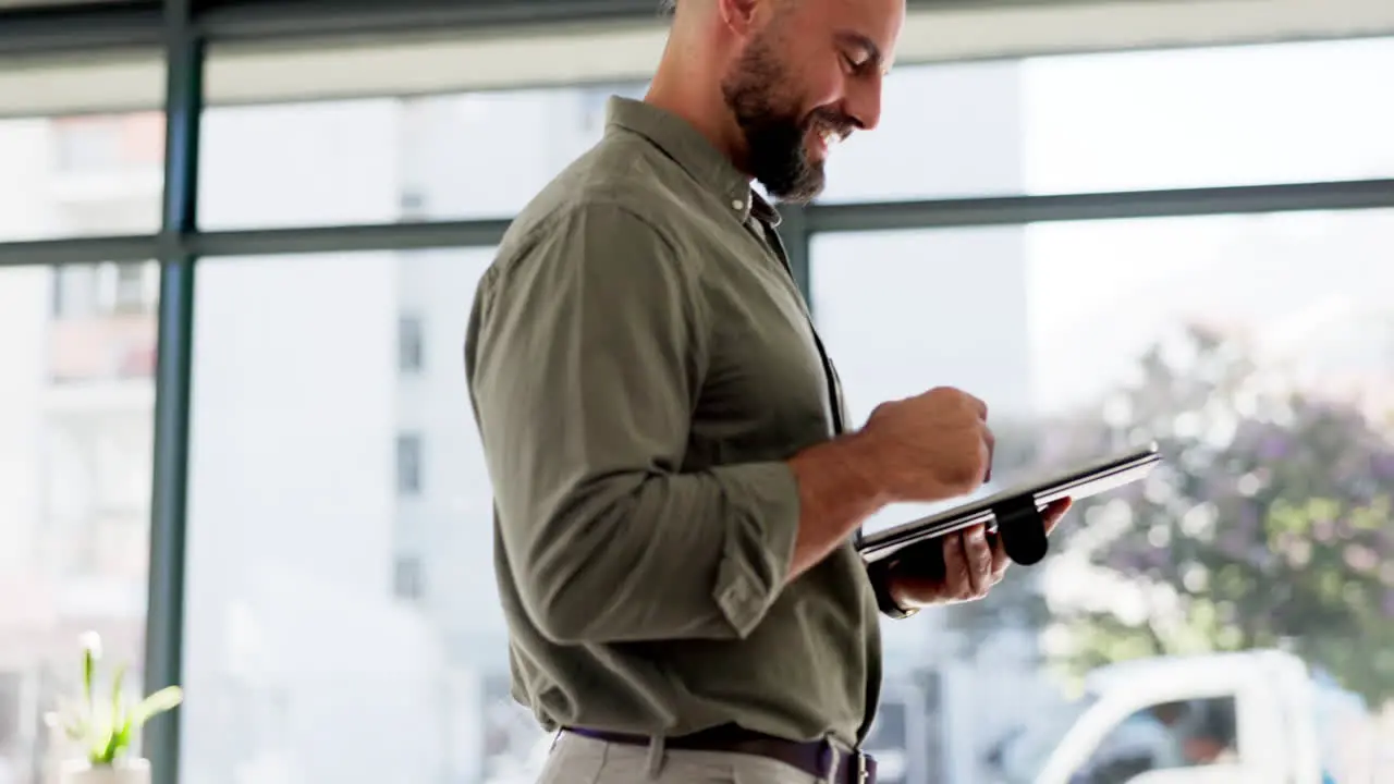 Happy man working on tablet in startup office