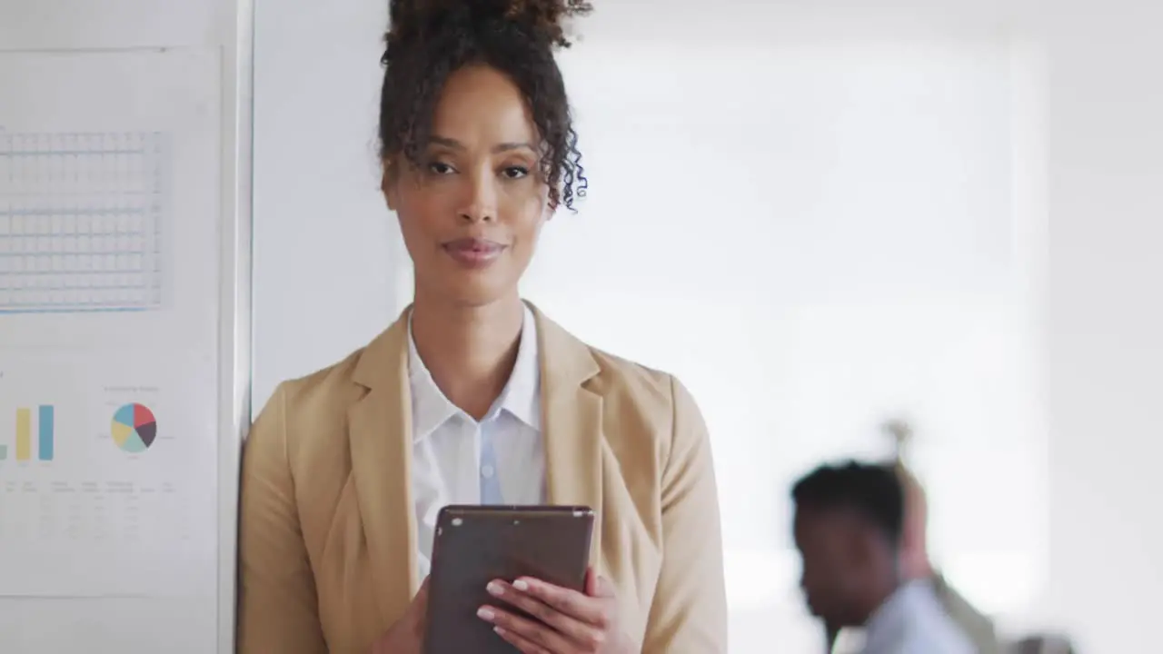 Portrait of happy african american businesswoman with tablet in creative office