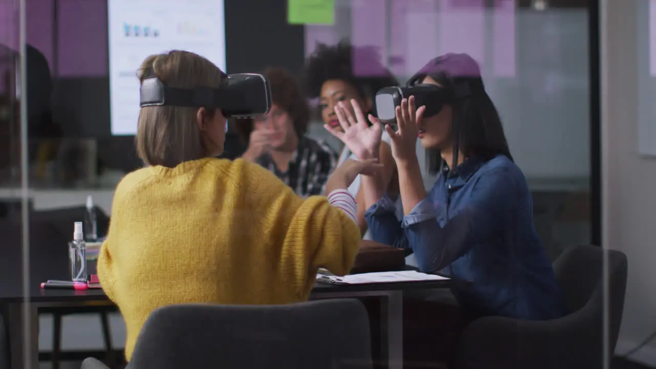 Diverse work colleagues sitting in meeting room wearing virtual reality glasses