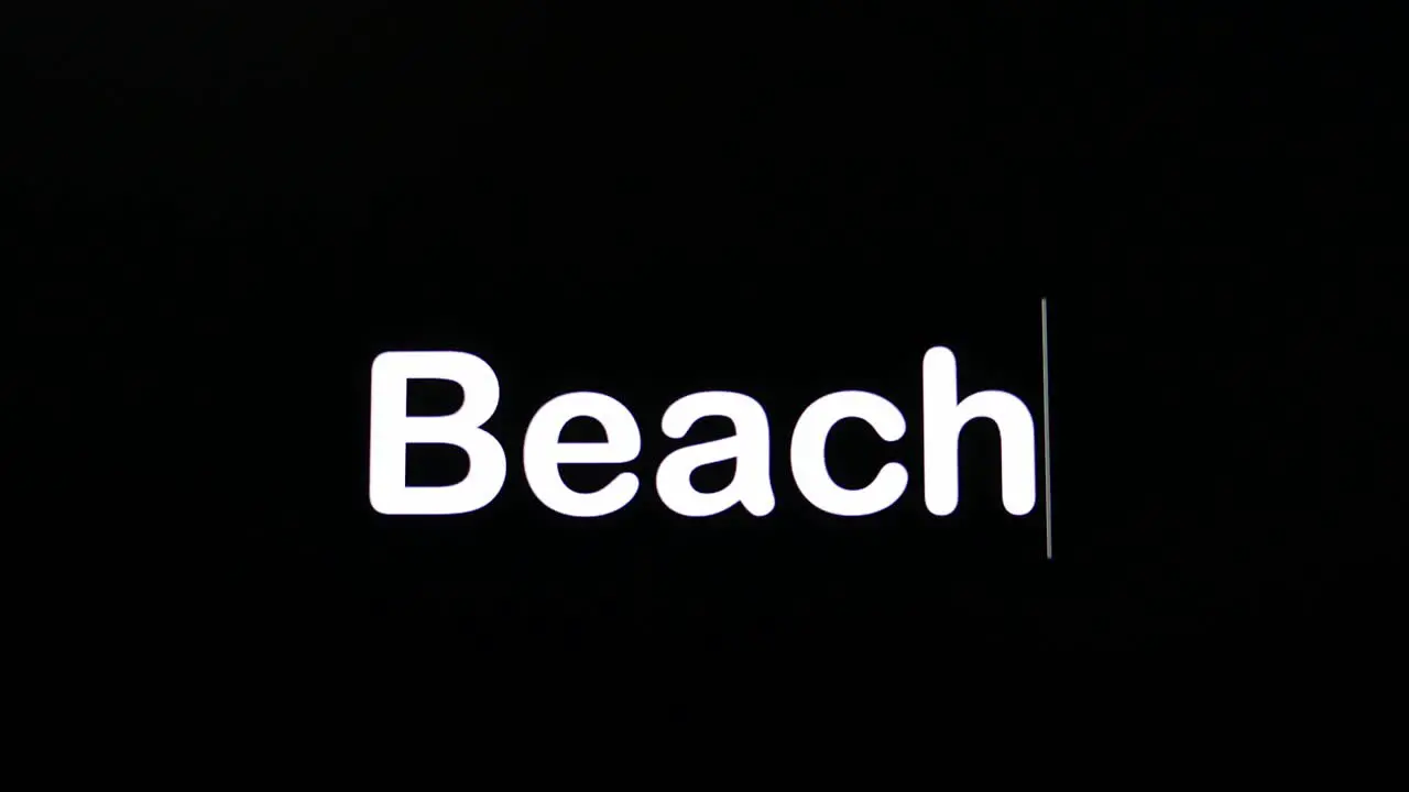 Typing on a dark background with the word Beach