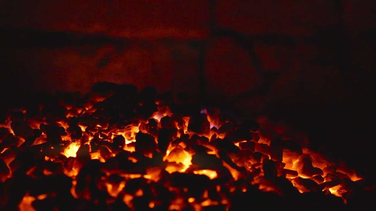 Fiery coals in dark stove nighttime heat source close-up