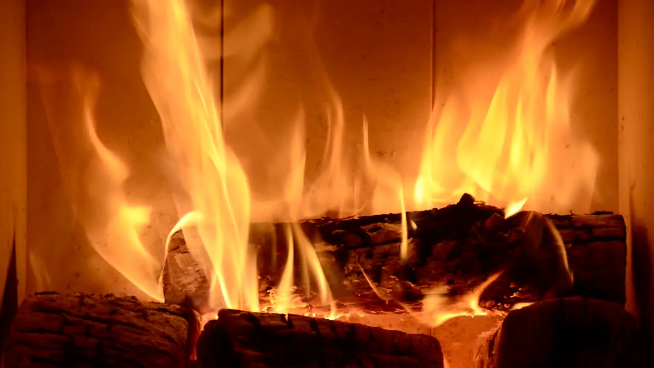 close up of home fireplace with wooden fire burning for heating house during global crisis of gas supply