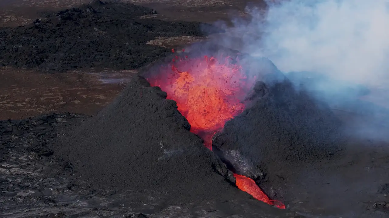 Powerful volcano eruption with lava flowing out of crater aerial