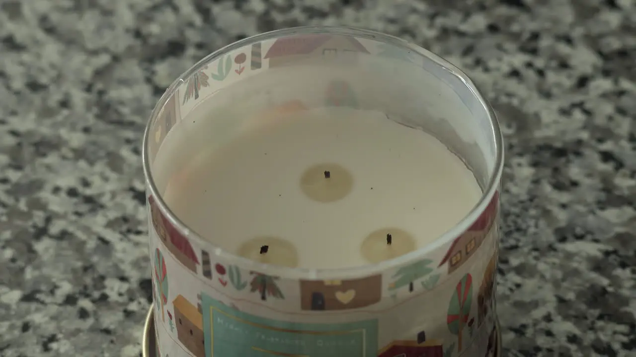 Close up on flickering lit candle on countertop being blown out 4K