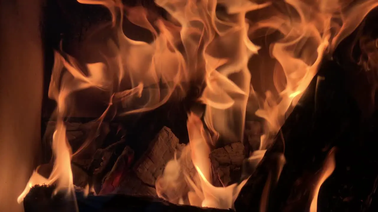 yellow vibrant fire flame burning woods pieces in fireplace at home