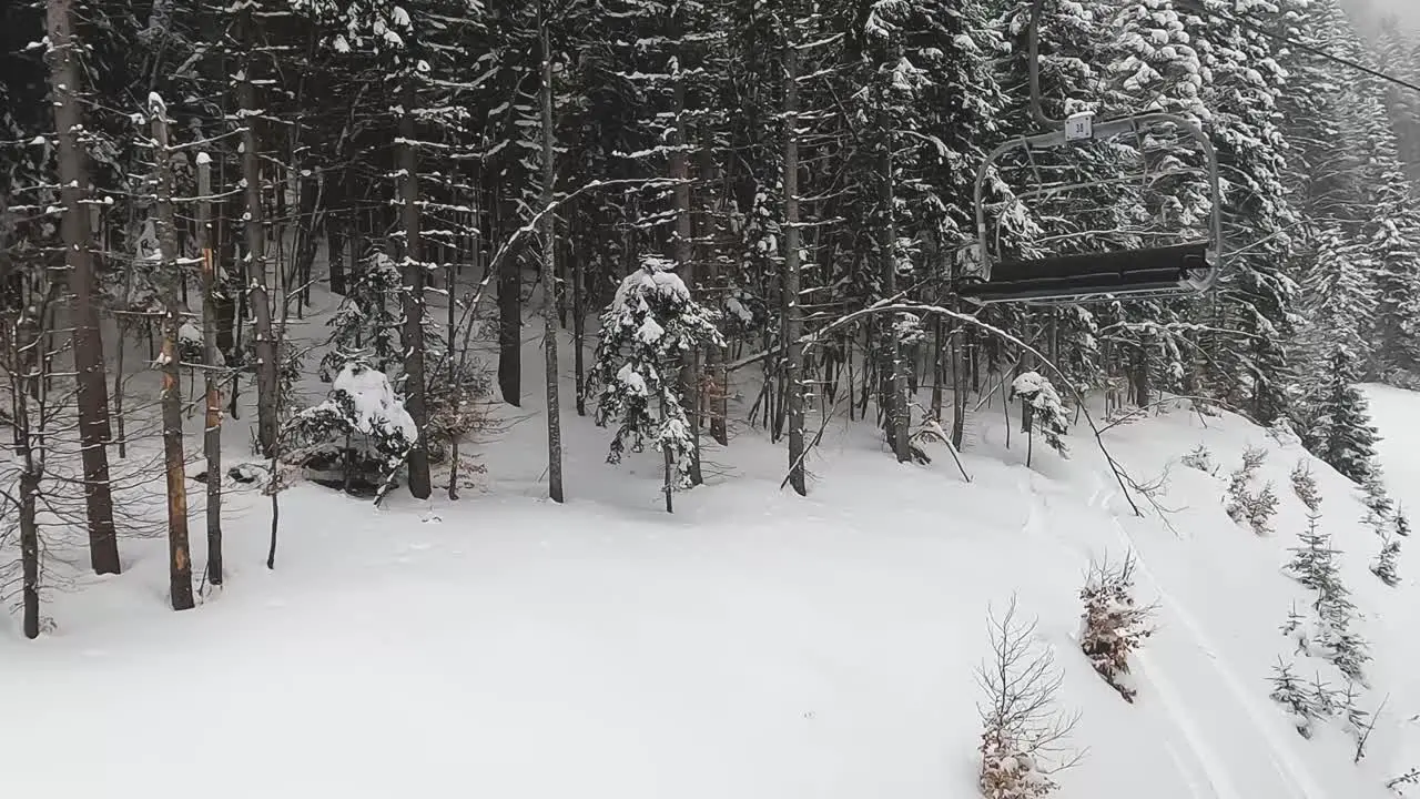 Skier Chair Lift Above Snow Covered Mountain And Trees