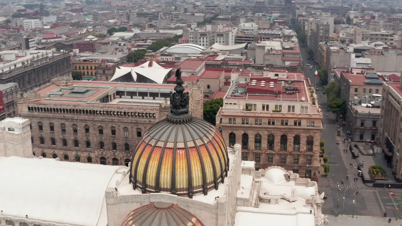 Drone camera flying around colorful dome with bird sculpture of Palace of fine arts (Palacio de Bellas Artes) in historic city center Mexico city Mexico