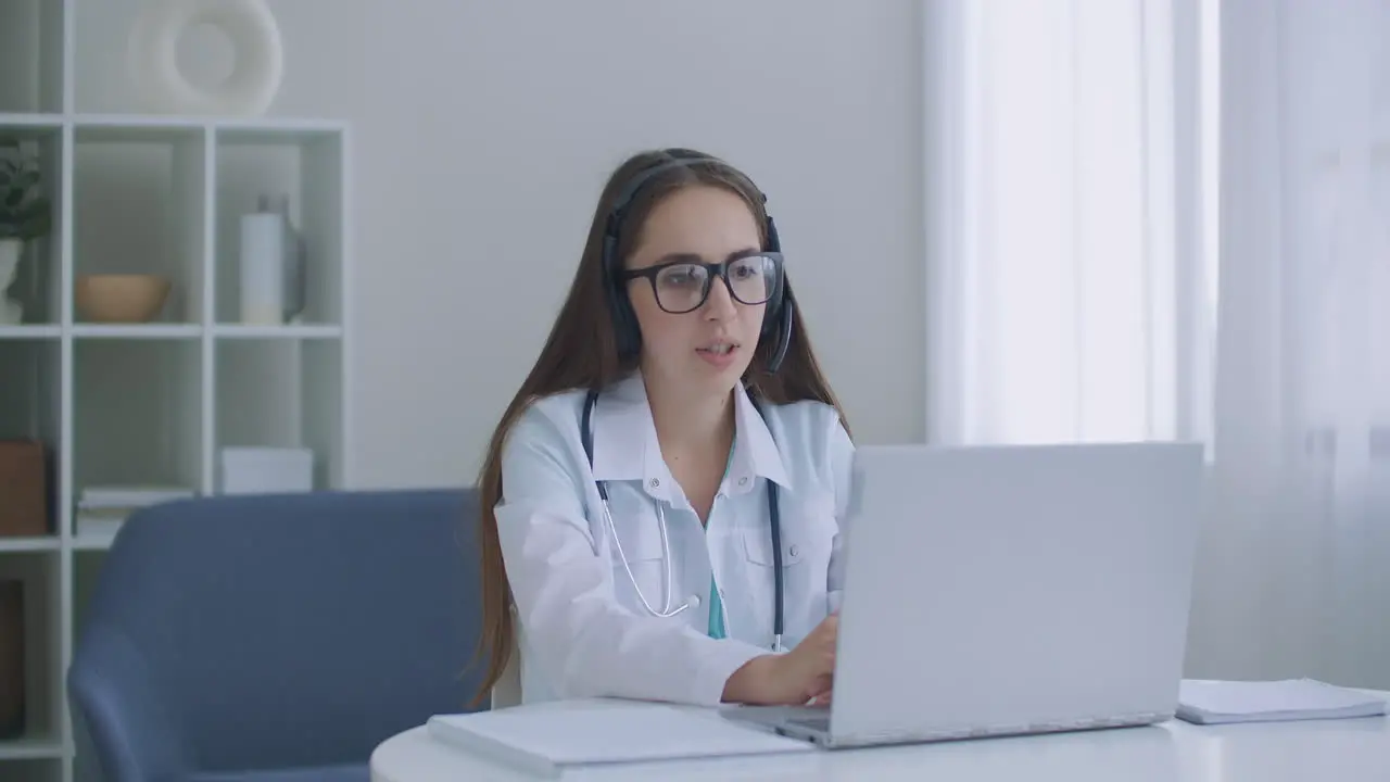 Hardworking Indian Female Doctor doing Video Call on Laptop in hospital Smiling young female doctor wear white uniform stethoscope consulting online patient via video call