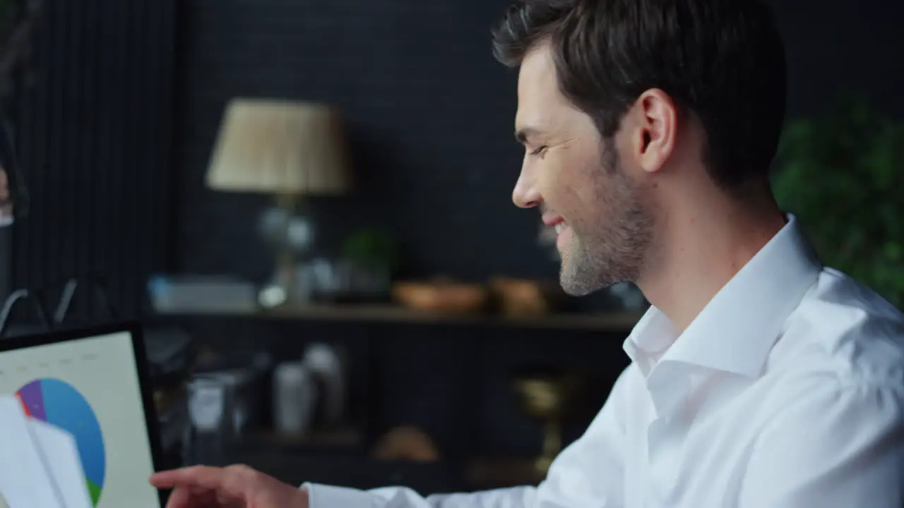 Businessman looking at graphs on laptop screen at office Manager using laptop