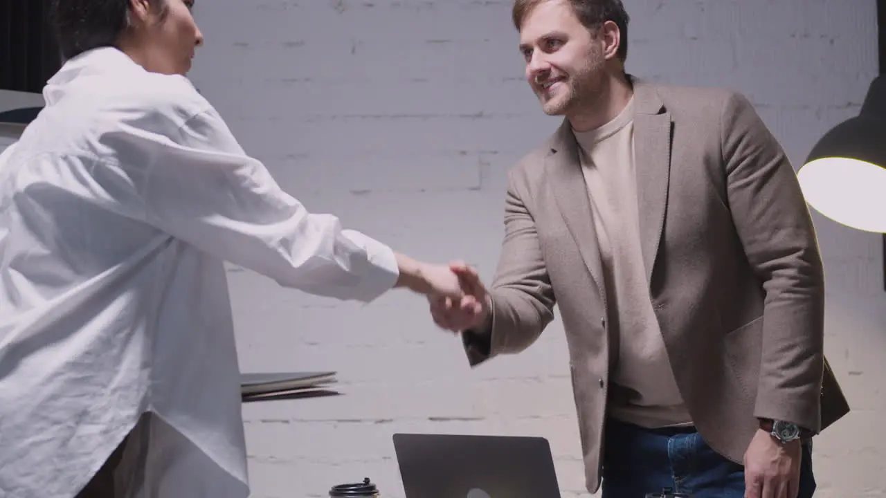 Businessman And Businesswoman Finishing Meeting With Handshake