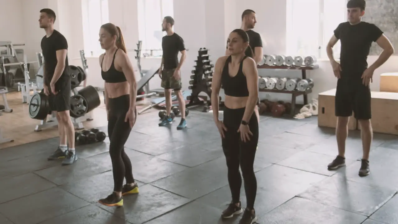 A Group Of Young Men And Women Do Stretching Exercises In The Gymnasium