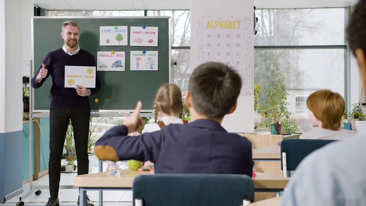 Teacher Teaches A Multiethnic Students Group The Words 'Happy' And 'sad' In English Classroom 1