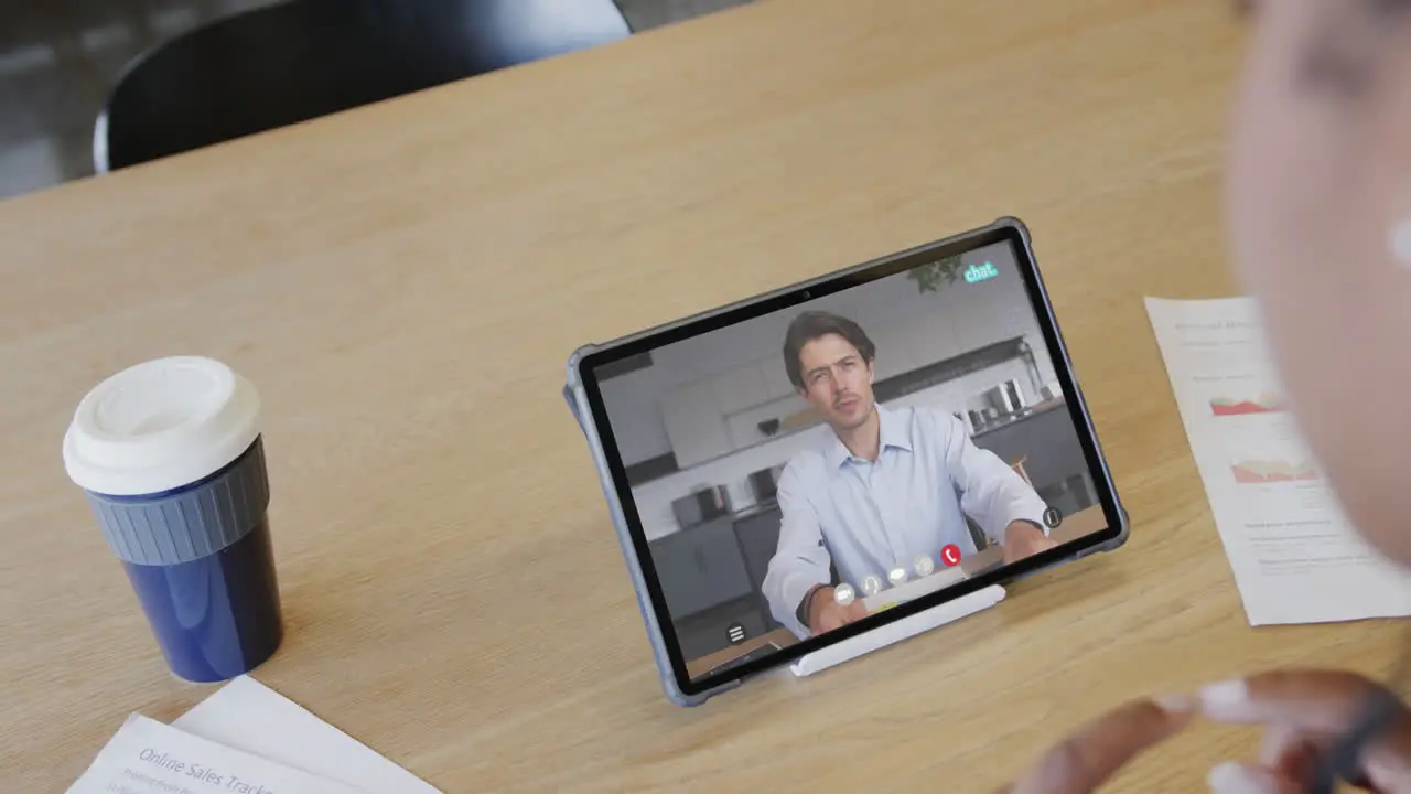 Caucasian businesswoman on laptop video call with african american male colleague on screen