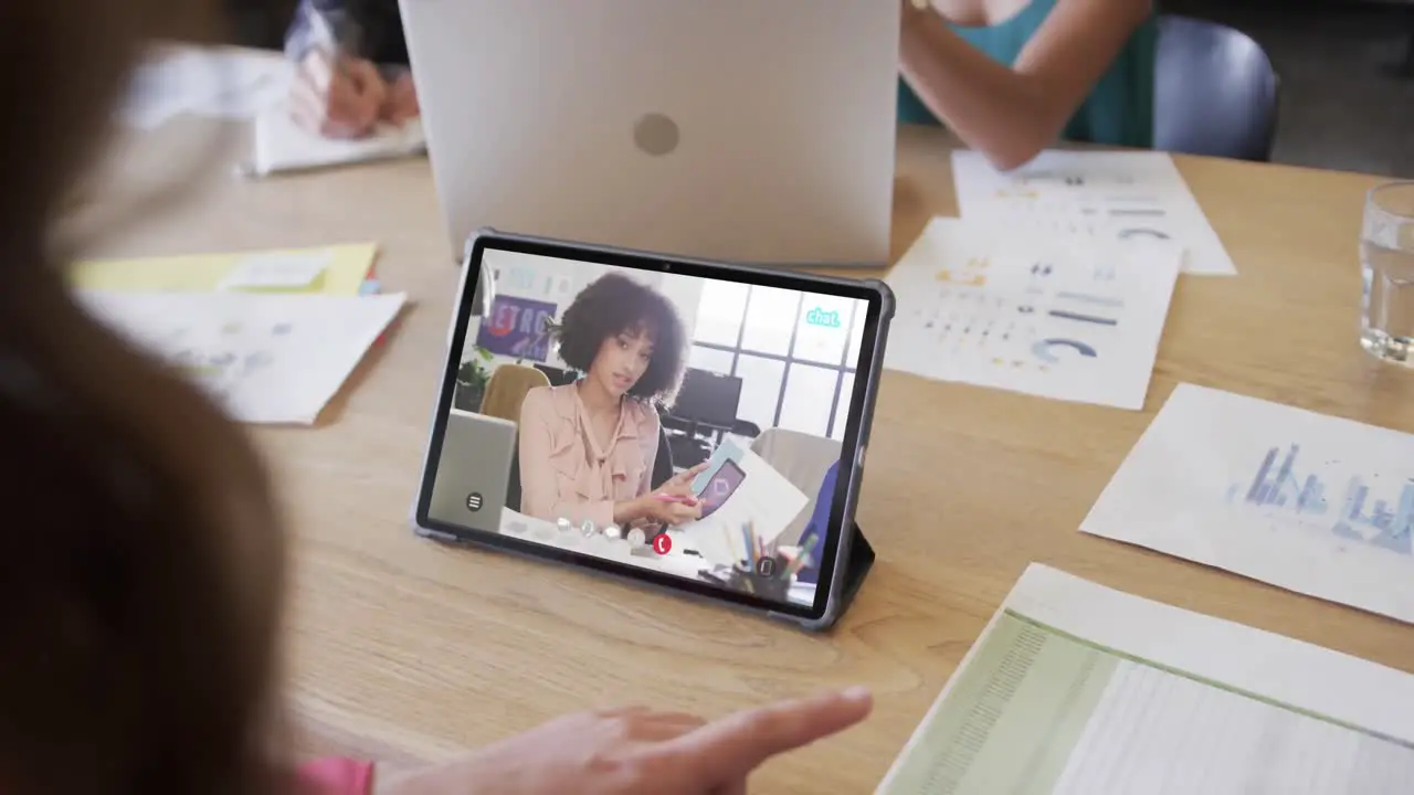 Caucasian businesswoman on tablet video call with african american female colleague on screen