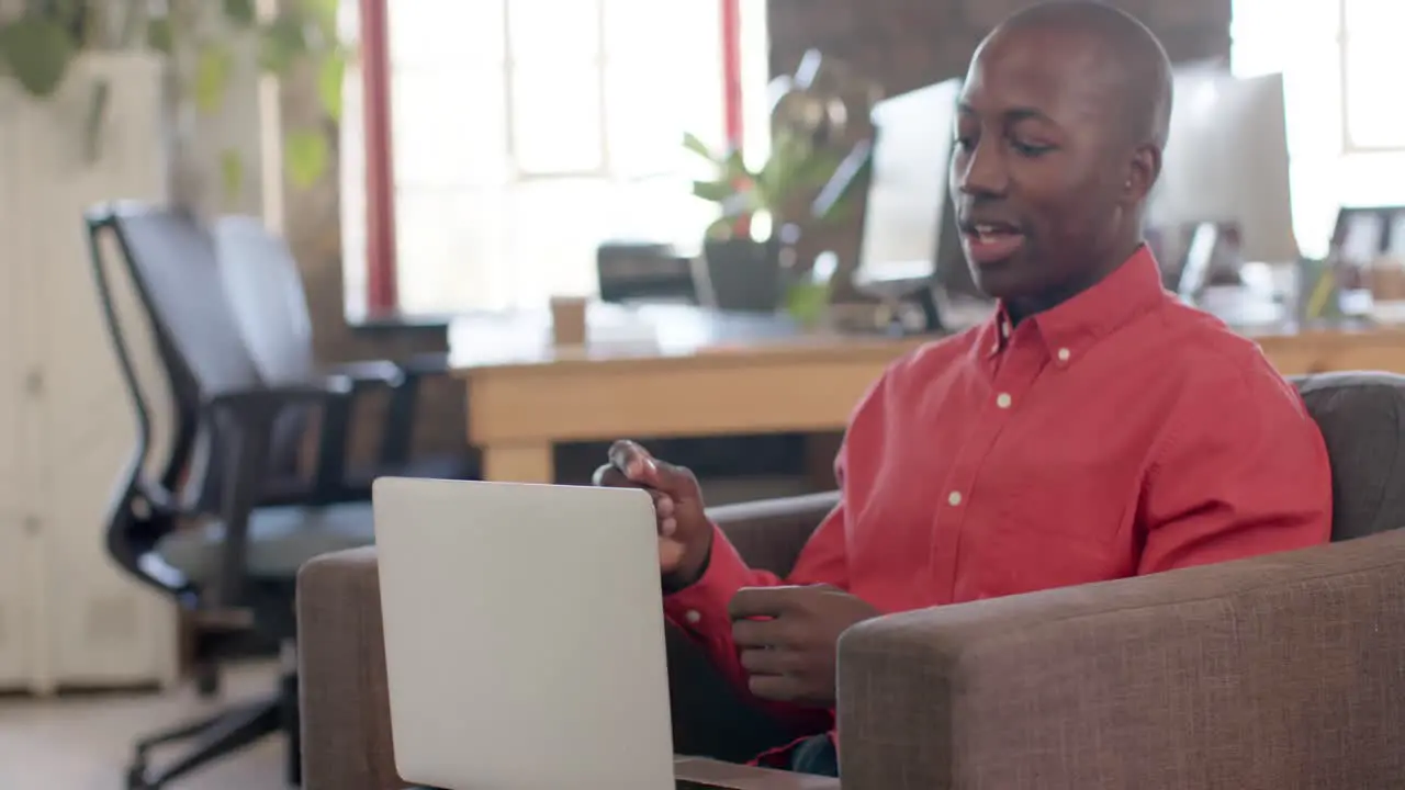 African american casual businessman having video call in creative office slow motion