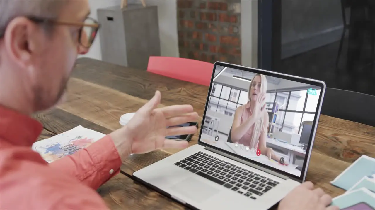 Caucasian businessman on laptop video call with caucasian female colleague on screen