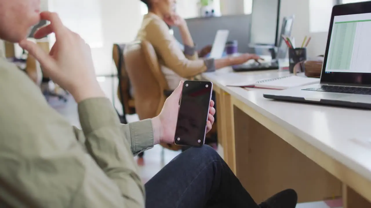 Albino african american businessman using smartphone with copy space in creative office