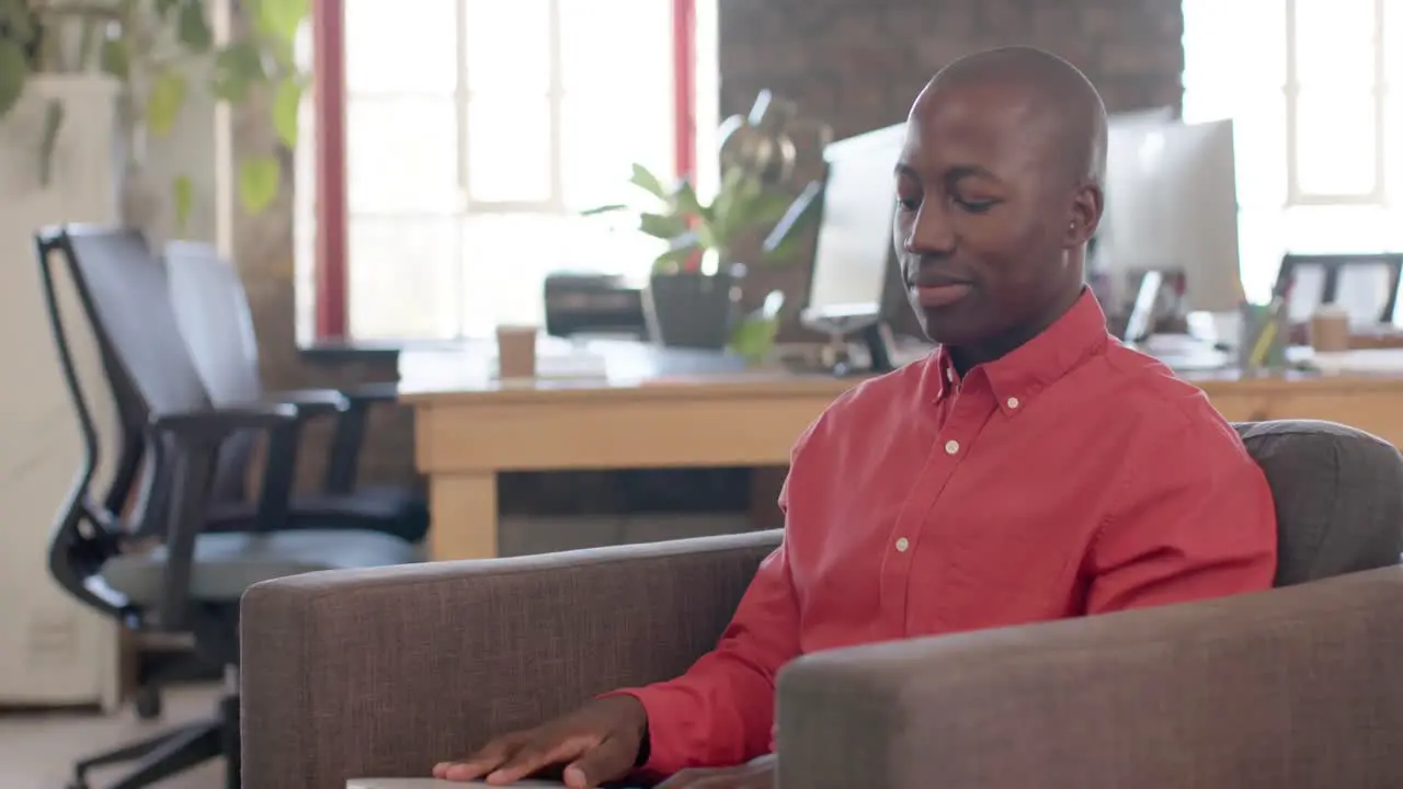 African american casual businessman closing laptop in creative office slow motion