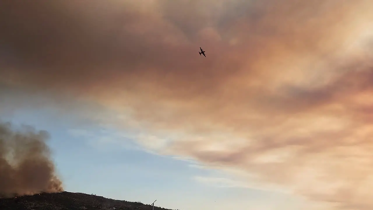 Small plane flying over forest fire Aerial firefighting