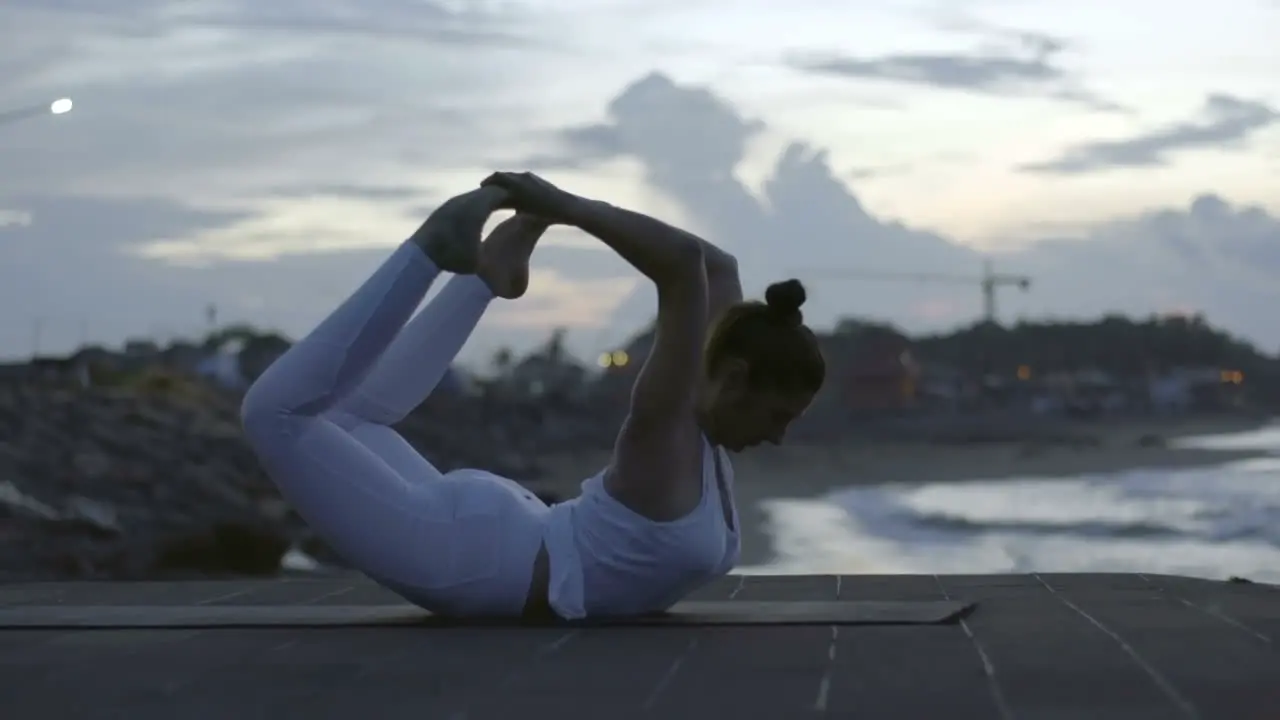 Woman In White Sportswear Doing A Yoga Posture On The Beach