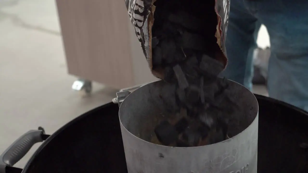 Black coals are added to charcoal grill slow motion