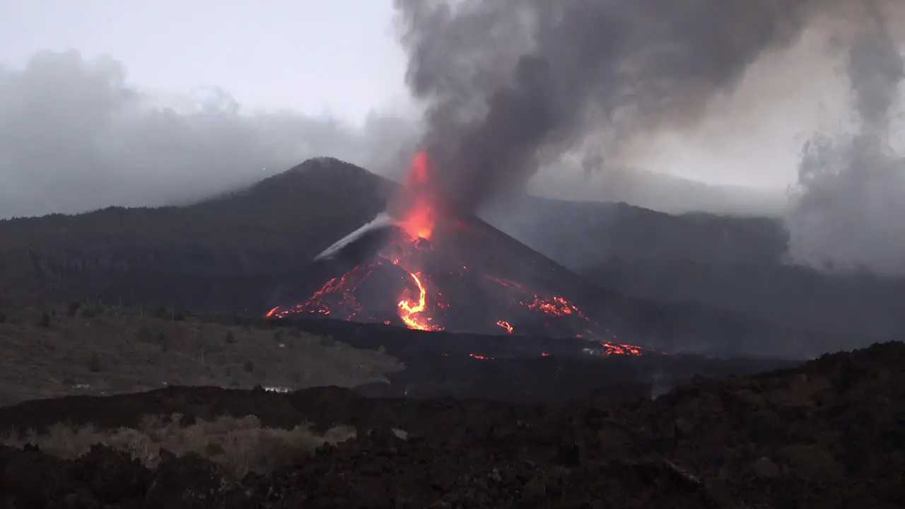 A huge new lava flow pours during the Cumbre Vieja volcano eruption seeming to set the whole mountainside on fire at sunset on La Palma in the Canary Islands