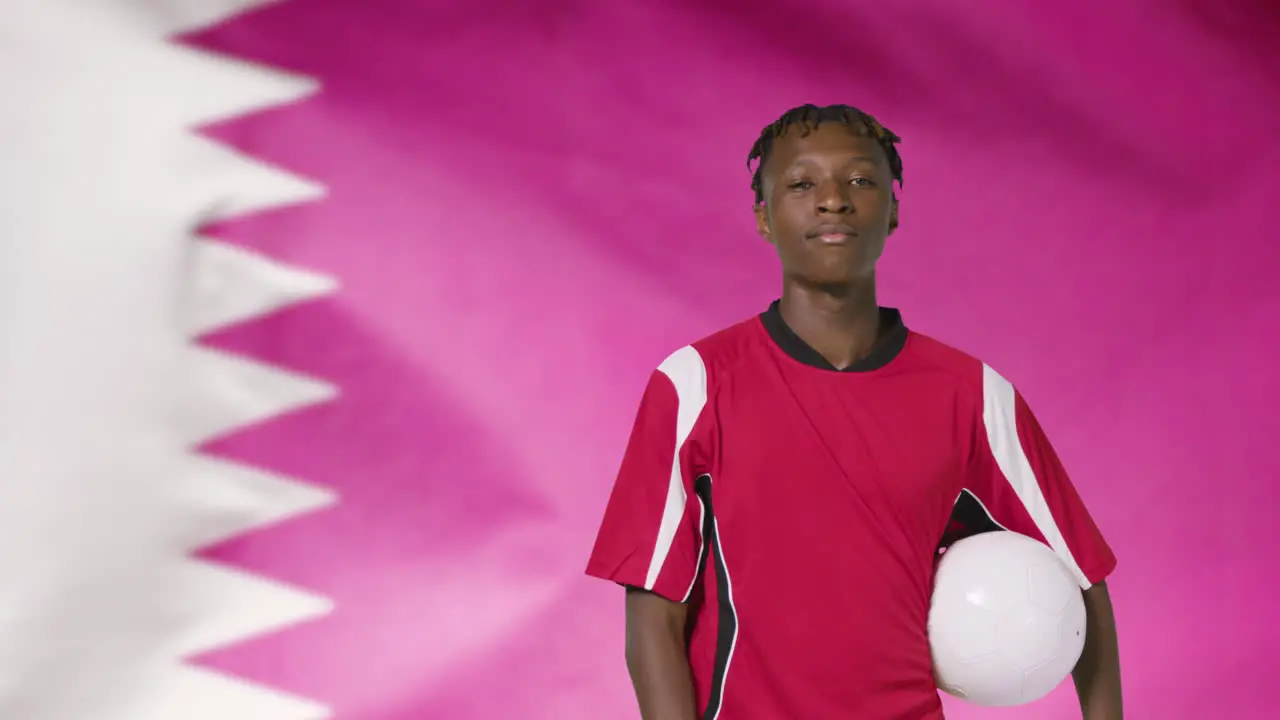 Young Footballer Walking to Camera In Front of Qatar Flag 01