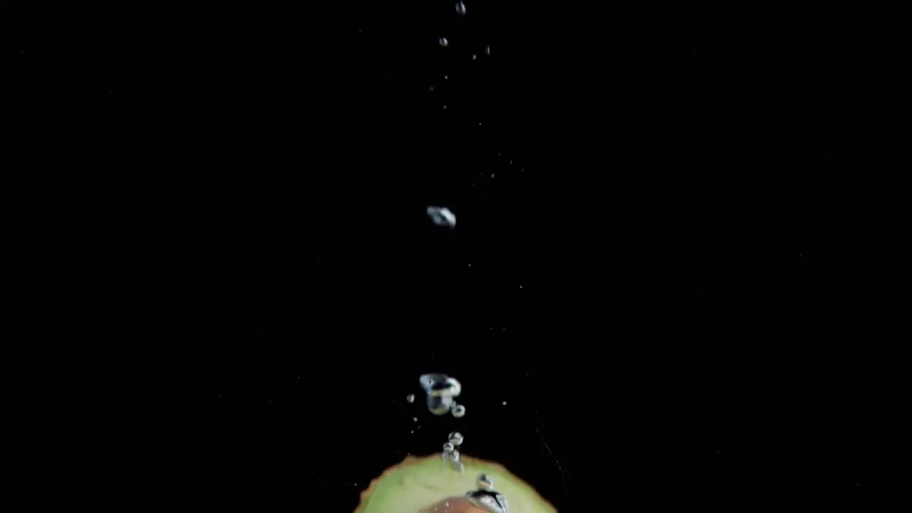 Avocado Falling into Water Super Slowmotion Black Background lots of Air Bubbles 4k240fps