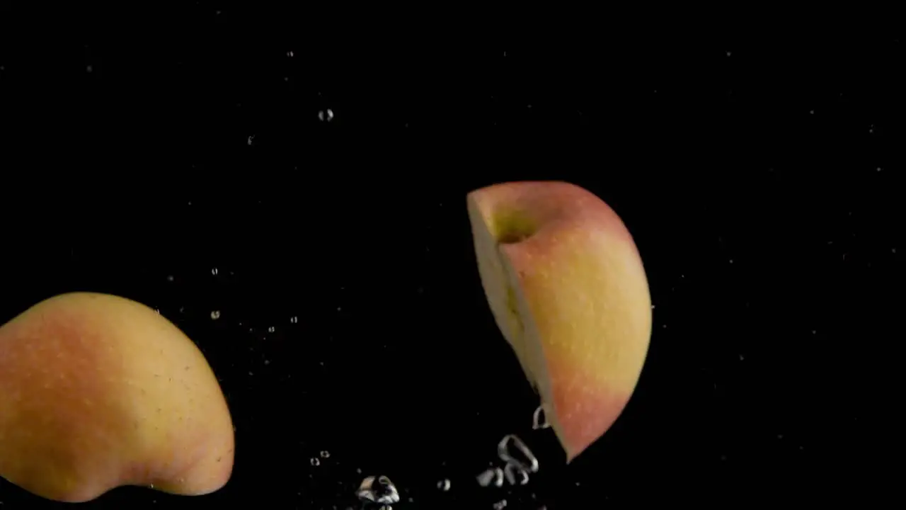 Apple Falling into Water Super Slowmotion Black Background lots of Air Bubbles 4k240fps