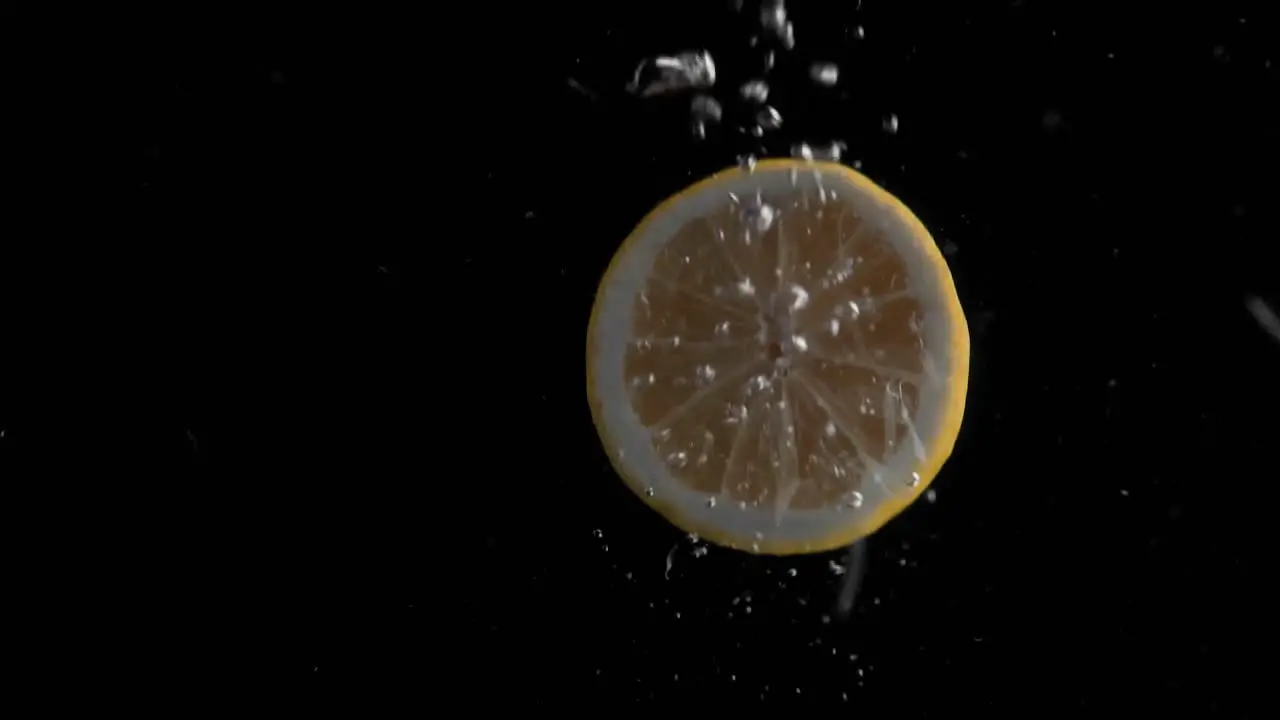 Lemon Falling into Water Super Slowmotion Black Background lots of Air Bubbles 4k240fps