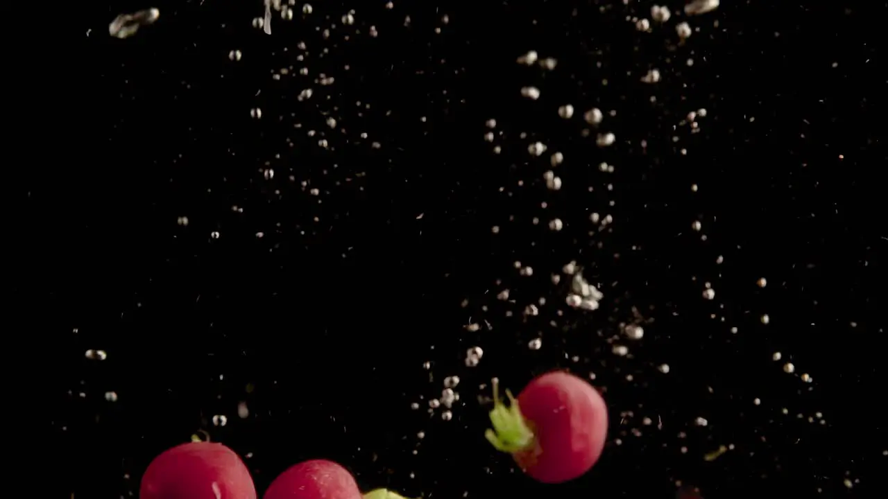 Radishes Falling into Water Super Slowmotion Black Background lots of Air Bubbles 4k240fps