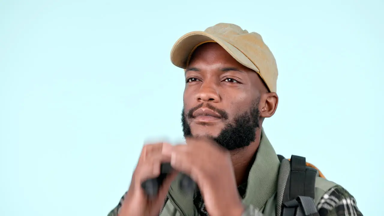 Black man in studio with binoculars for hiking