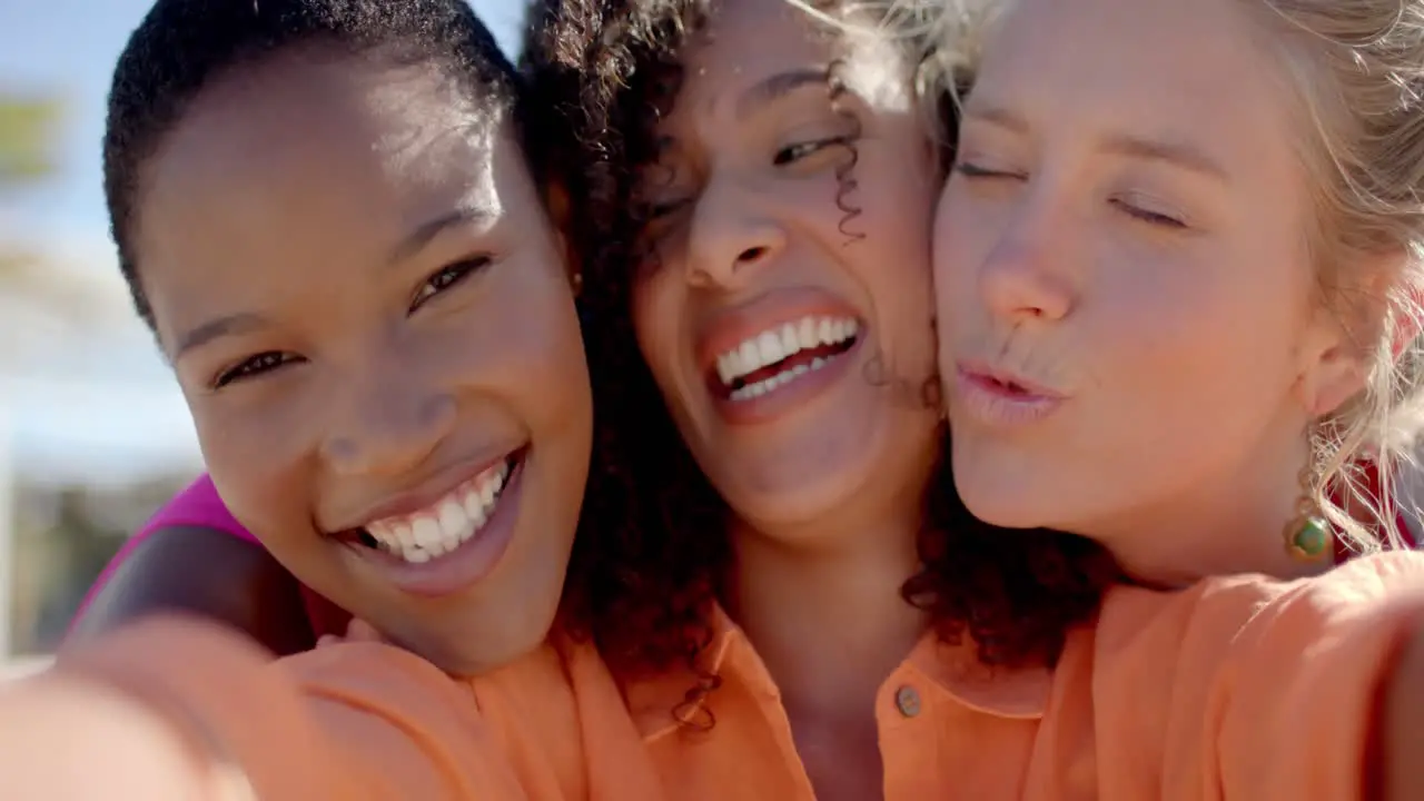 Portrait of happy diverse female friends embracing on beach