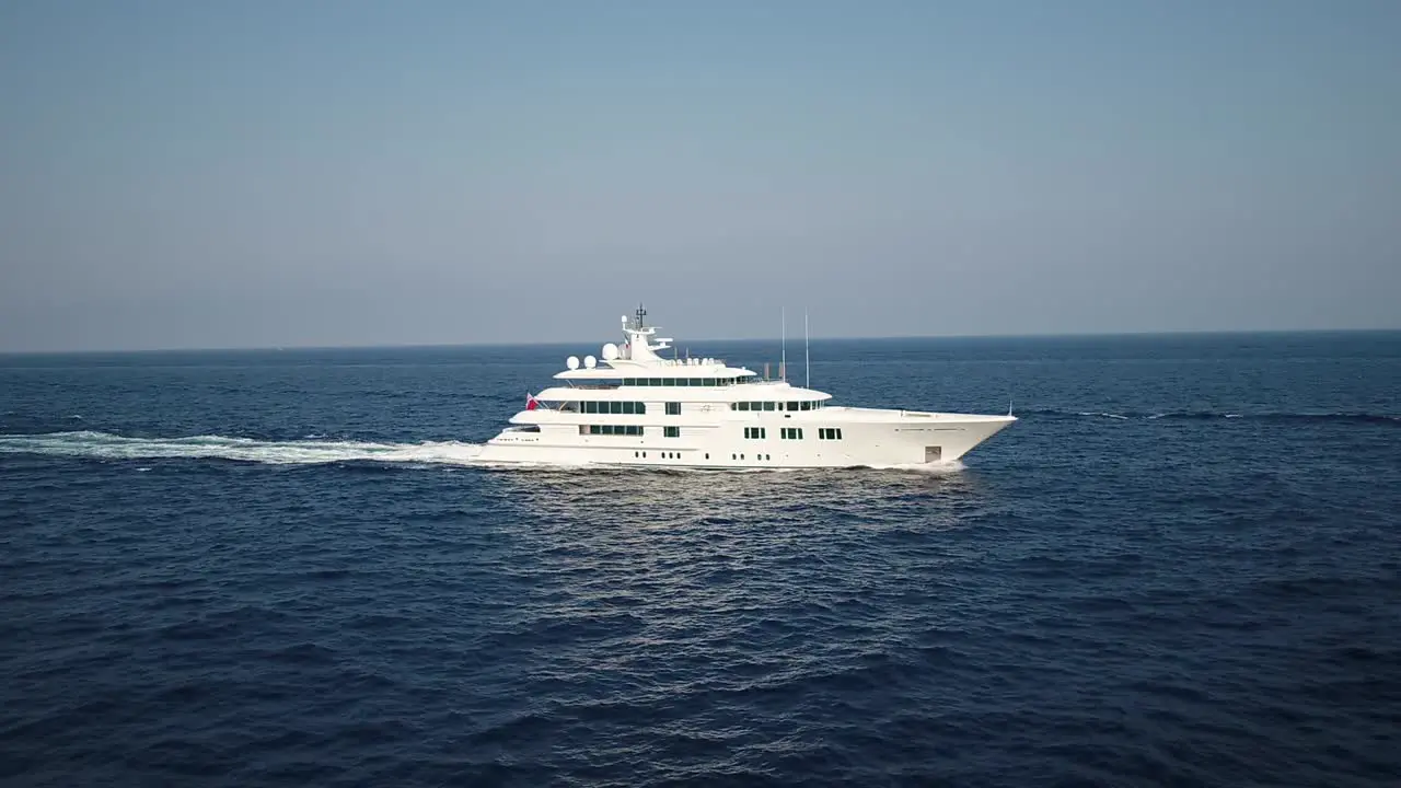 Aerial slide alongside a large luxury cruise ship on a blue sea