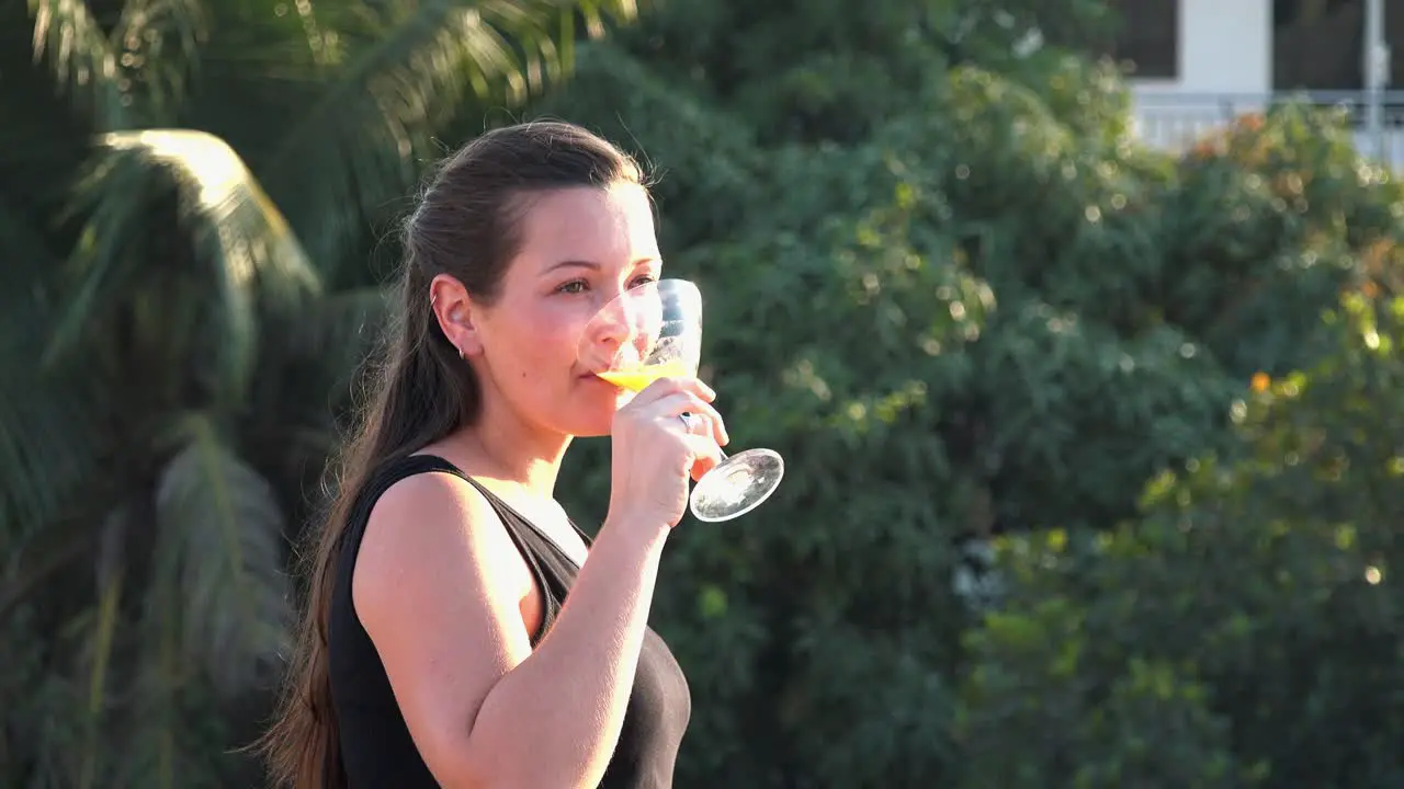 Close Shot of a Beautiful Young Lady Enjoying a Cocktail on a Tropical Hotel Rooftop