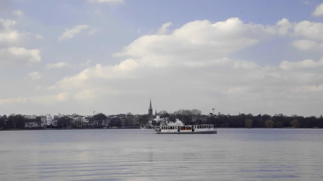 Barkasse boat on empty Alster Lake in Hamburg Germany against blue sky