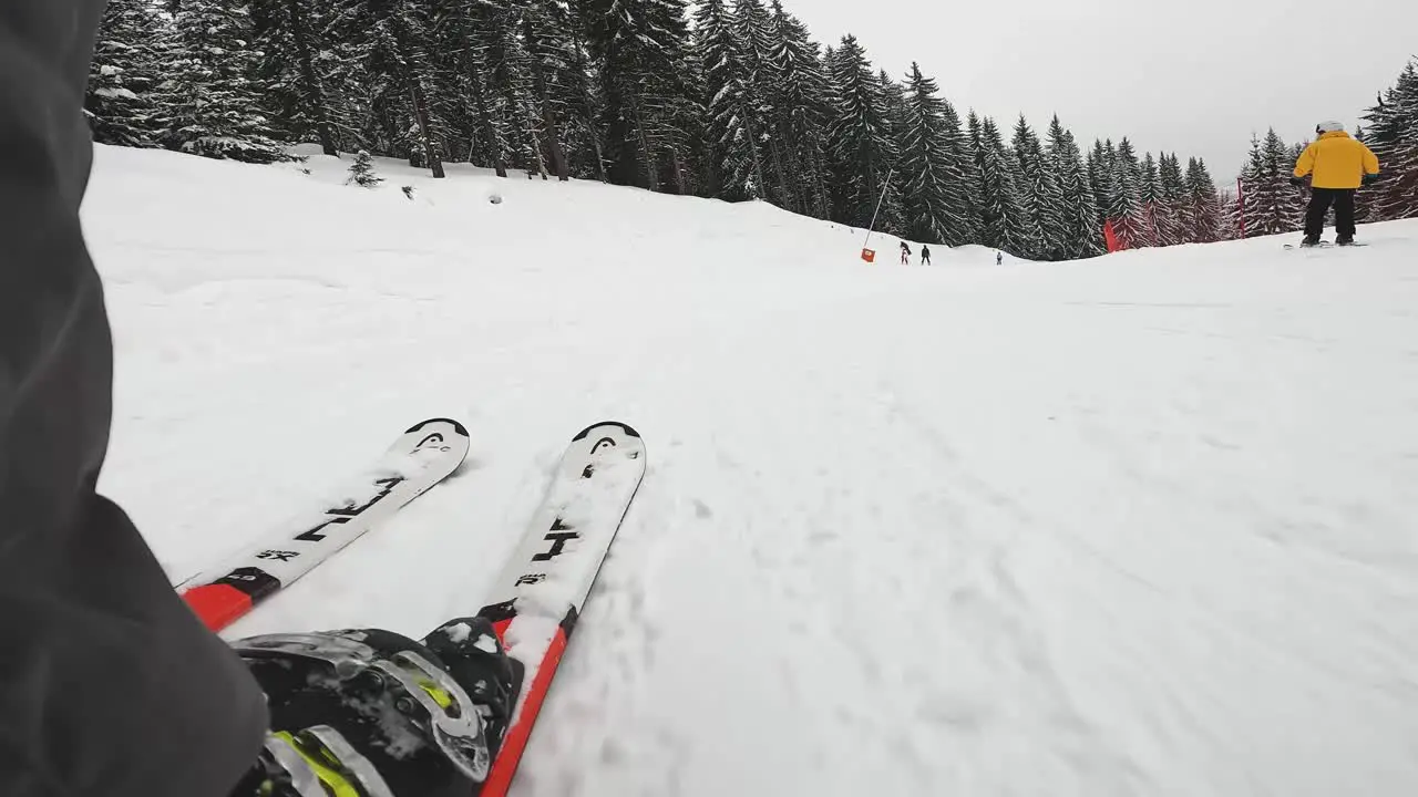 Low angle POV Shot Of Skier Skiing Down Misty Snow Covered Slope