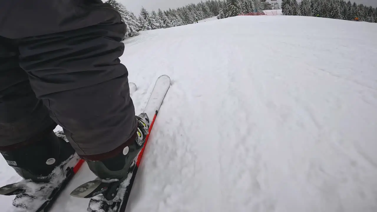 Low Angle POV Shot Of Skier Skiing Down Snow Covered Slope 1