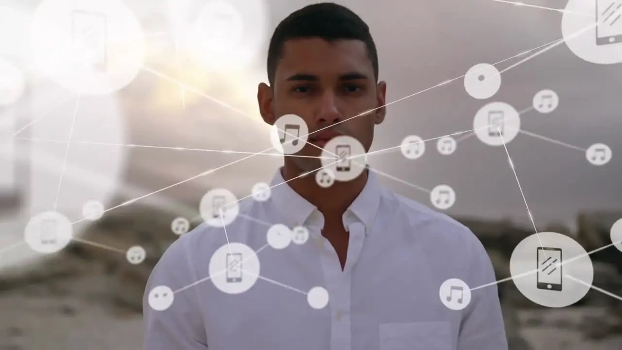 Network of digital icons against portrait of man standing at the beach