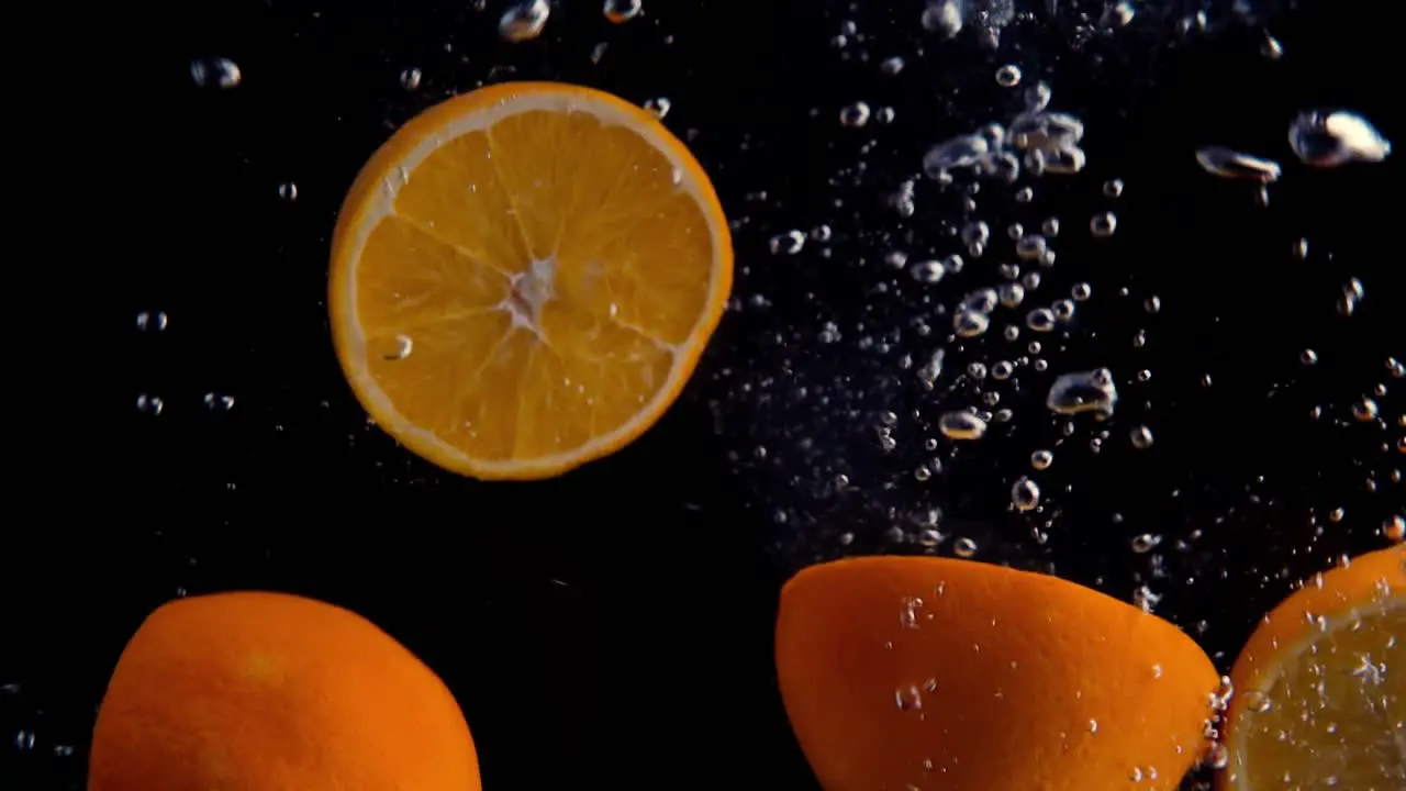 Oranges Falling into Water Super Slowmotion Black Background lots of Air Bubbles 4k240fps